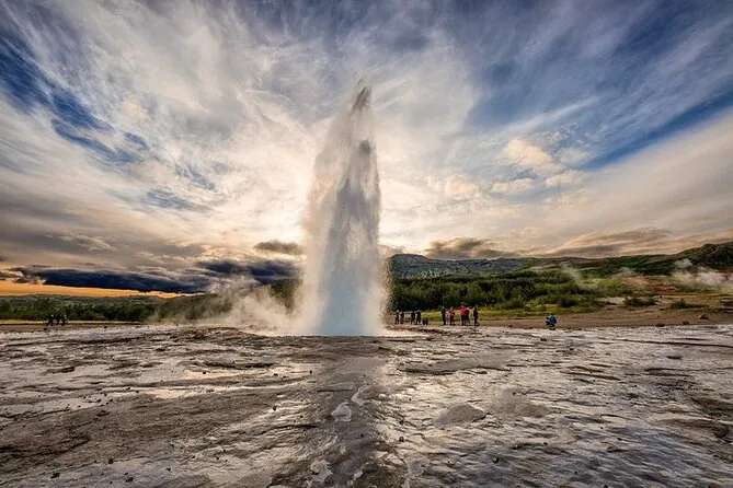 A geyser erupting beside a small crowd