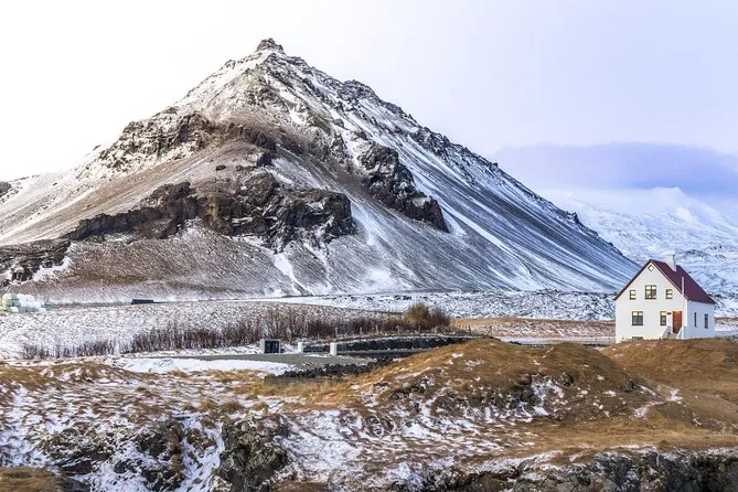Una montaña nevada sobre una casa blanca en invierno
